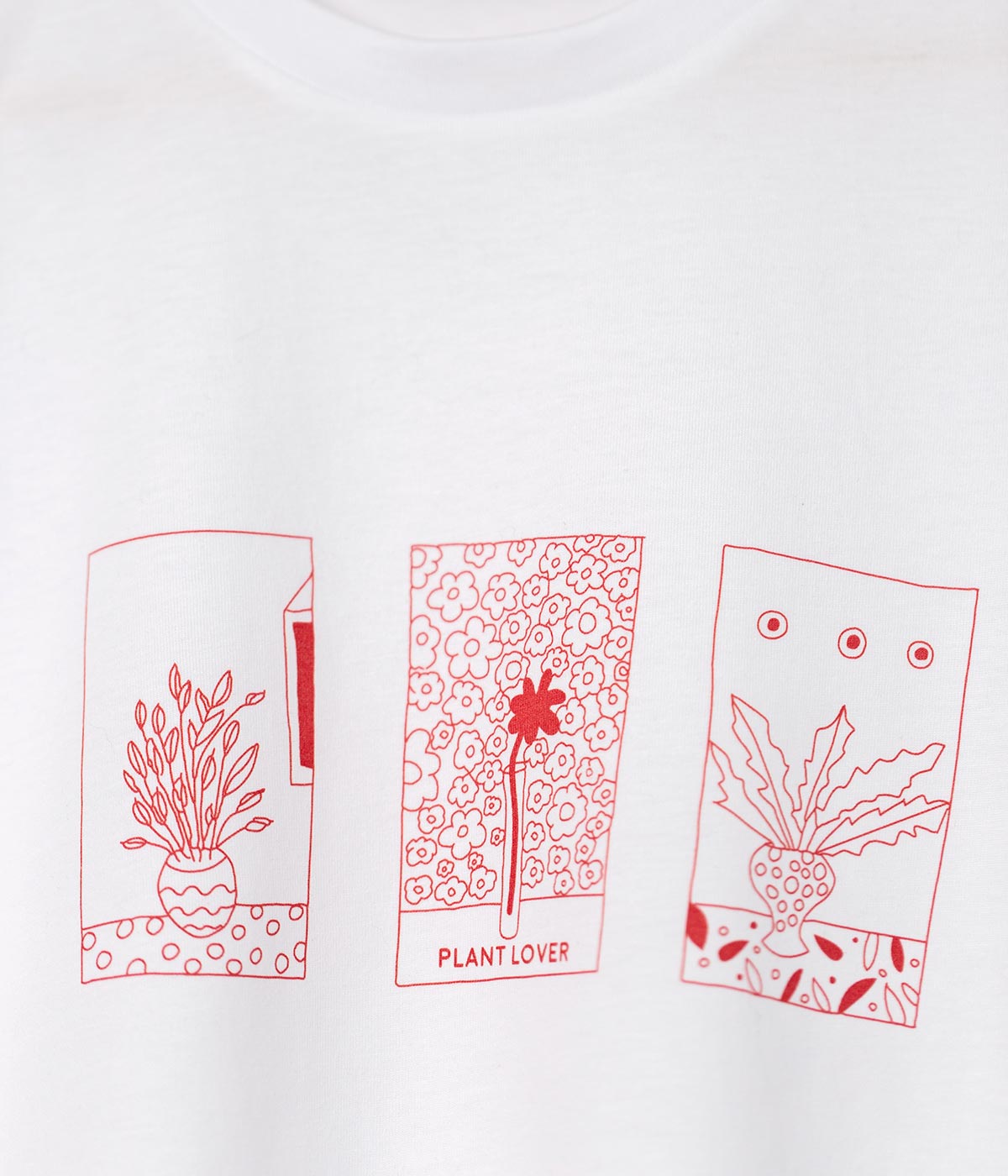 Close-up of white cotton t-shirt printed with red plants placed in 3 rectangles on chest.