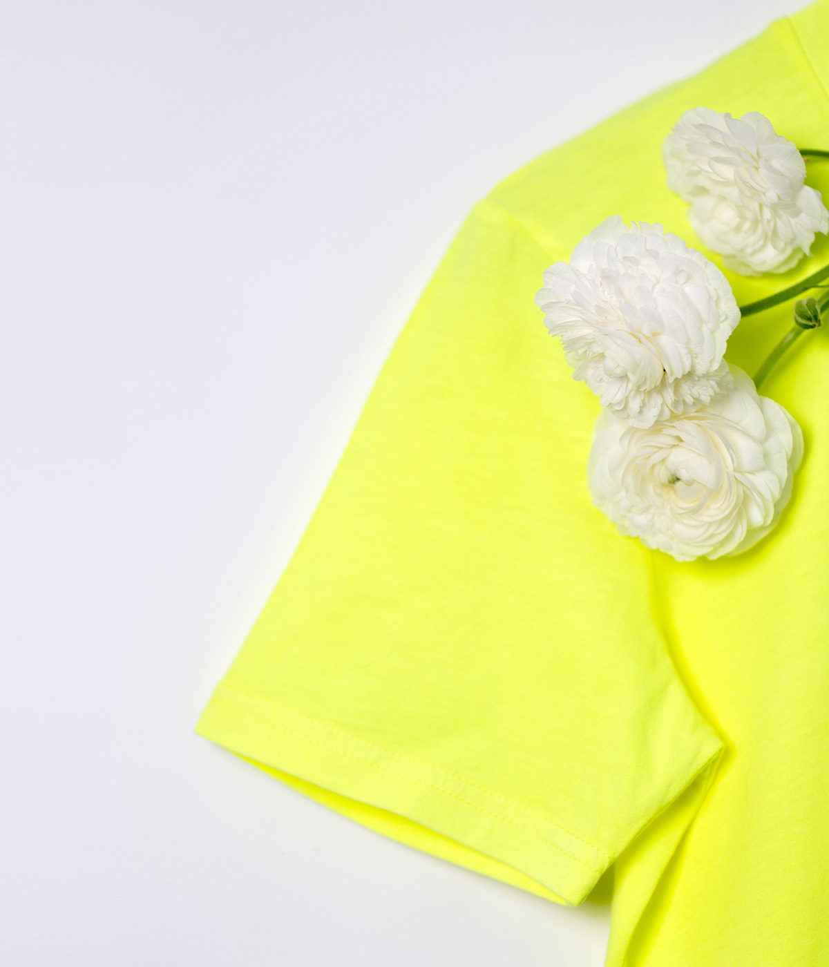 Close-up of neon yellow sleeve of cotton t-shirt.