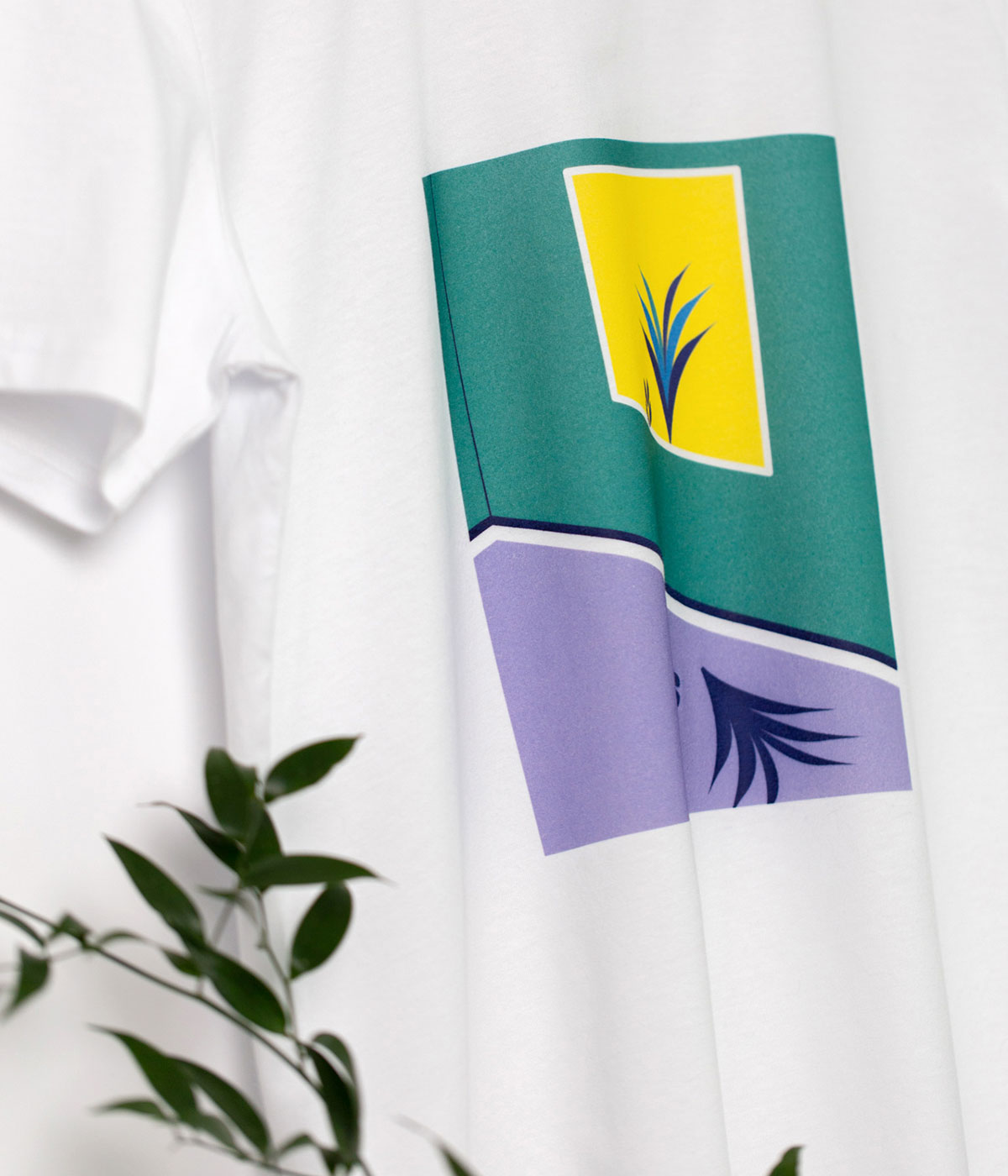 Detaliu print al unui tricou alb din bumbac cu print cu plante colorate in mov, galben & verde & plasate intr-un dreptungi.