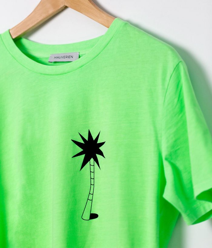 Detaliul unui tricou verde neon cu print cu palmier negru.