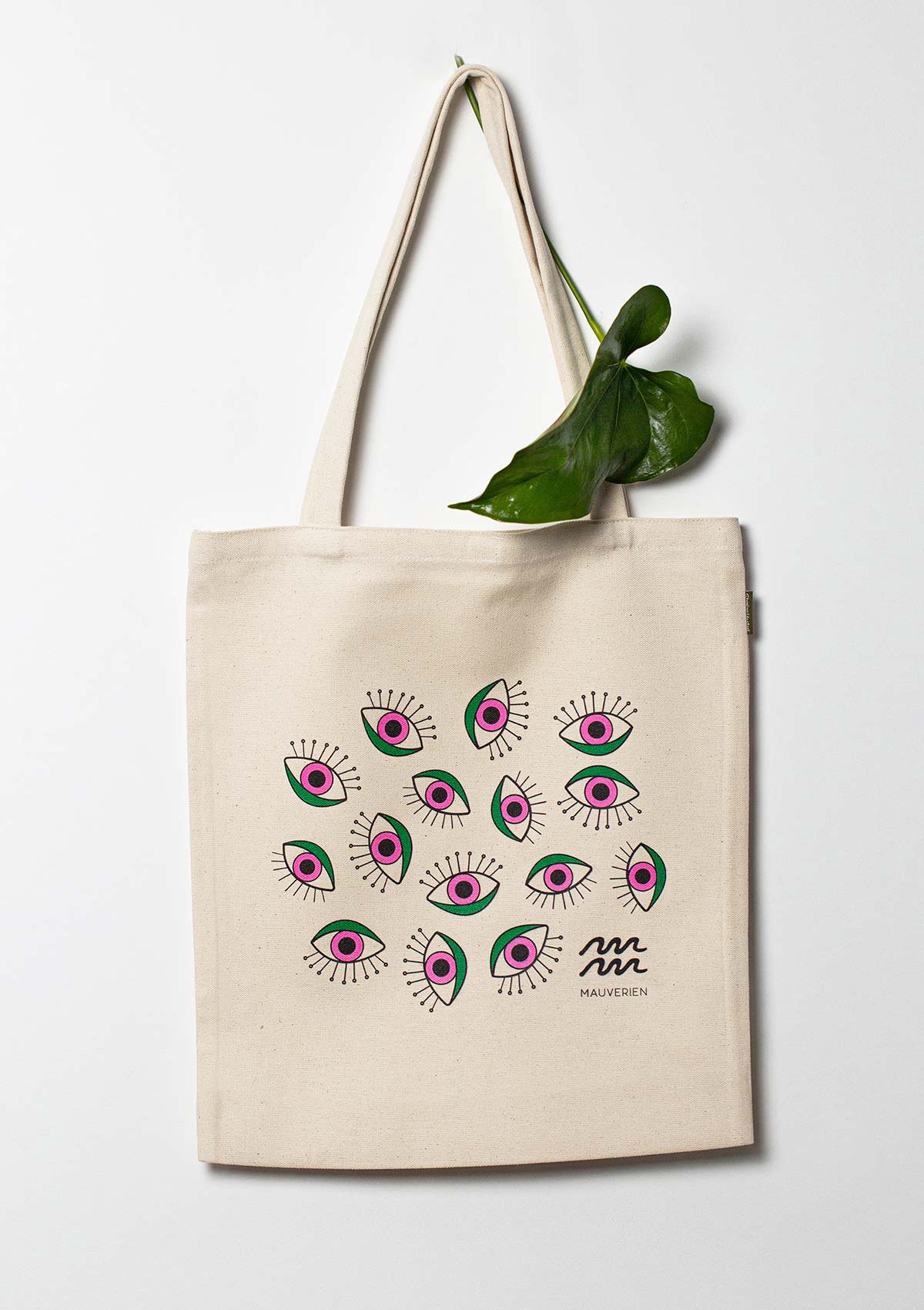 Organic cotton tote bag with eyes printed in green and magenta and Mauverien black logo placed at the bottom right.
