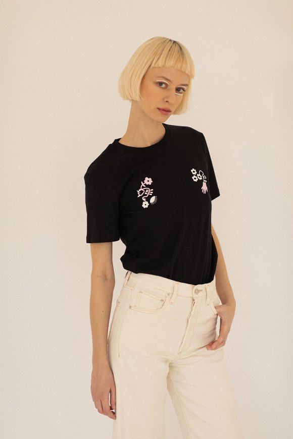 Woman wearing black t-shirt by Romanian designer and white jeans.