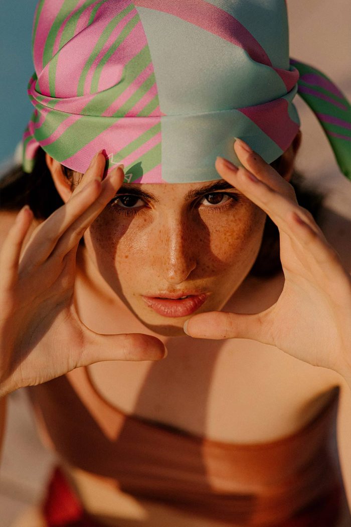Woman wearing blue and pink head scarf by Romanian designer Mauverien.