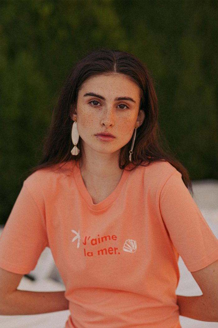 Woman wearing orange t-shirt La Mer by Romanian designer Mauverien.