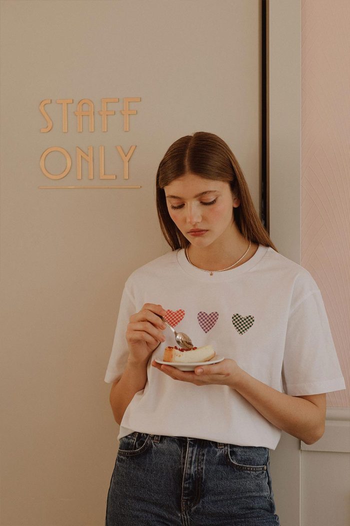 Woman wearing white oversized cotton t-shirt with 3 hearts print.