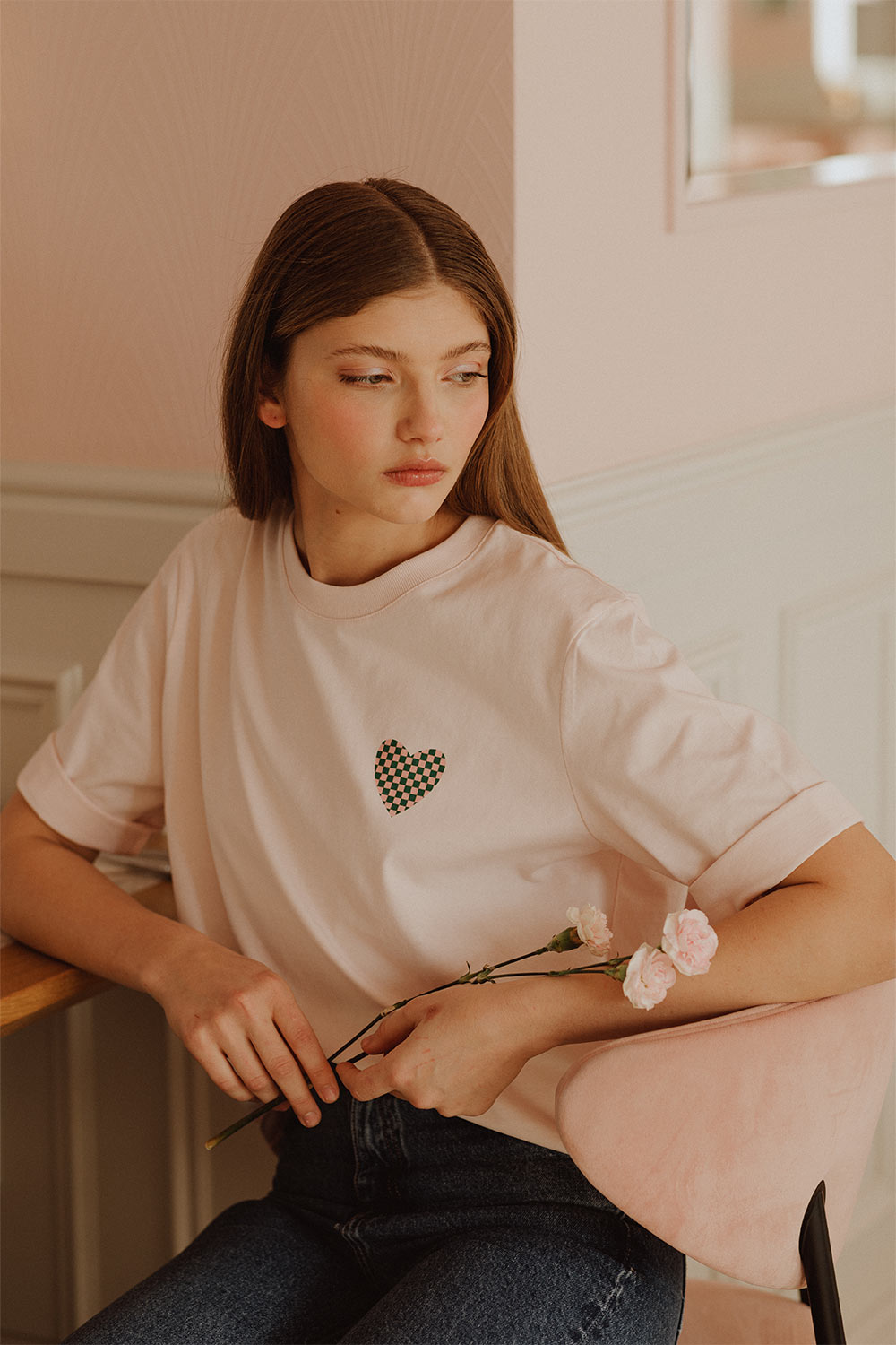 Woman wearing light pink t-shirt with heart print by Romanian designer Mauverien.