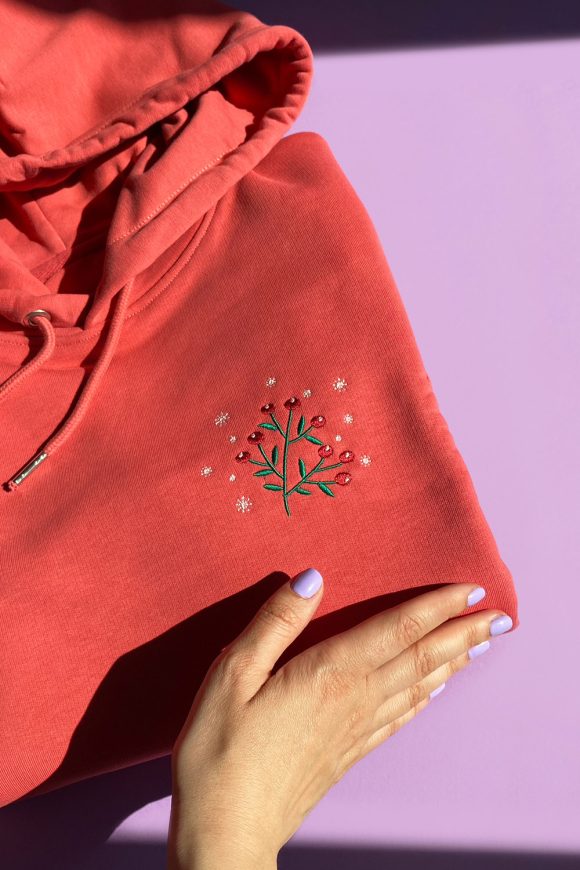 Detail of berries embroidery on red hoodie.