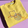 Close up of yellow cotton embroidered sweatshirt with abstract shapes.